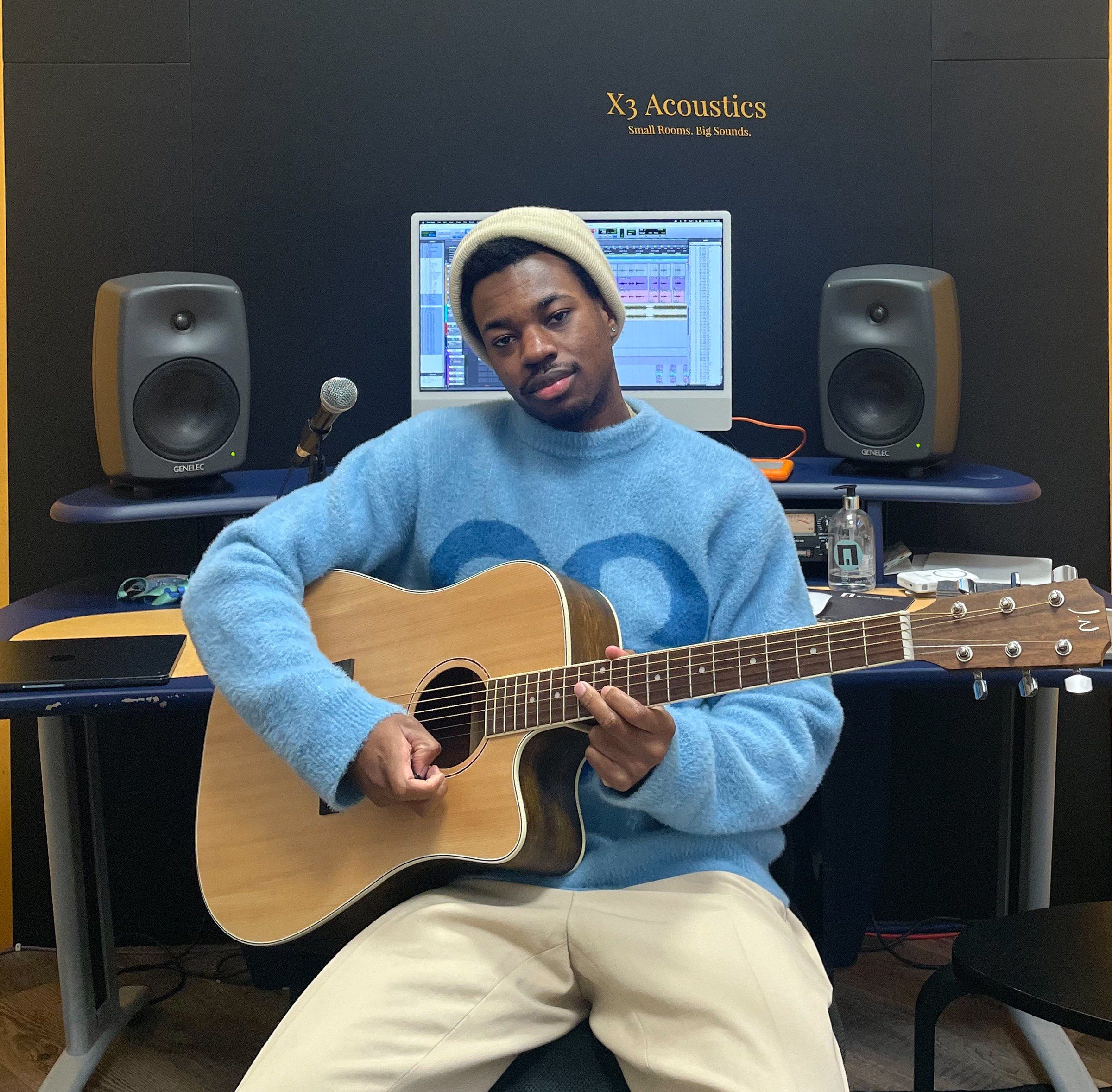 Victor Rouvreau, guitare à la main, dans un studio d'enregistrement